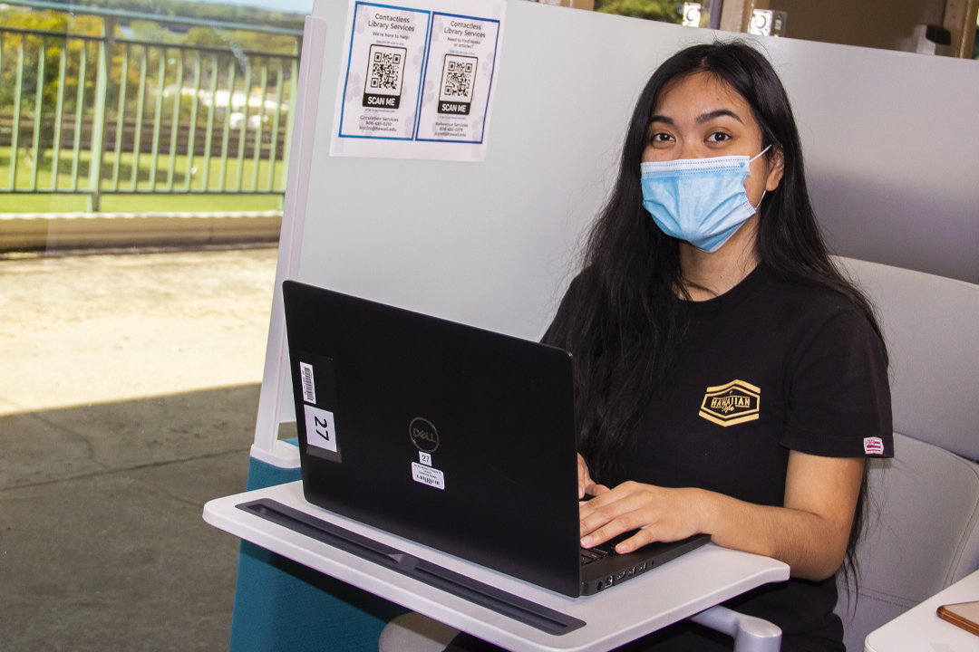 female student at study desk in library