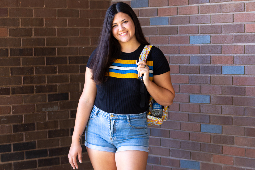 Female student posing in front of wall