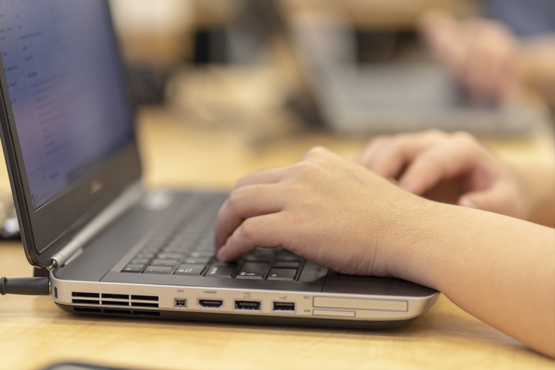 closeup of hands on a laptop keyboard