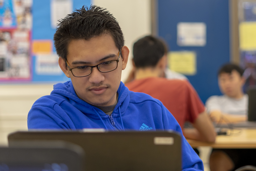 male student checking his laptop screen